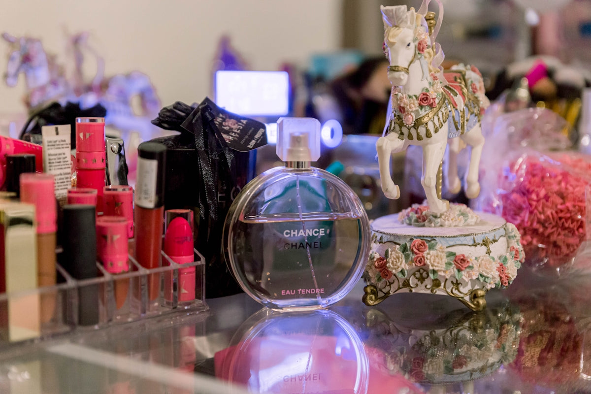 a glass table topped with lots of bottles of perfume