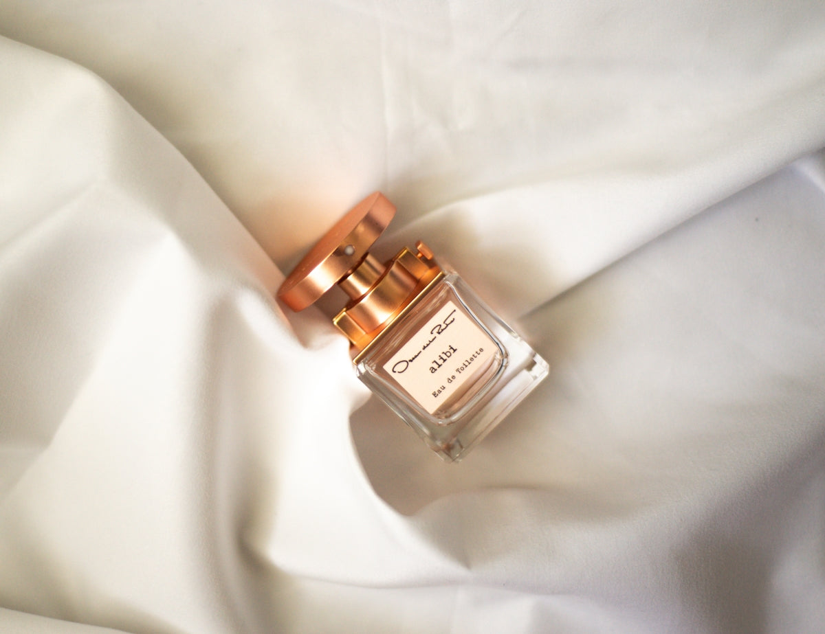 a bottle of perfume sitting on top of a white sheet